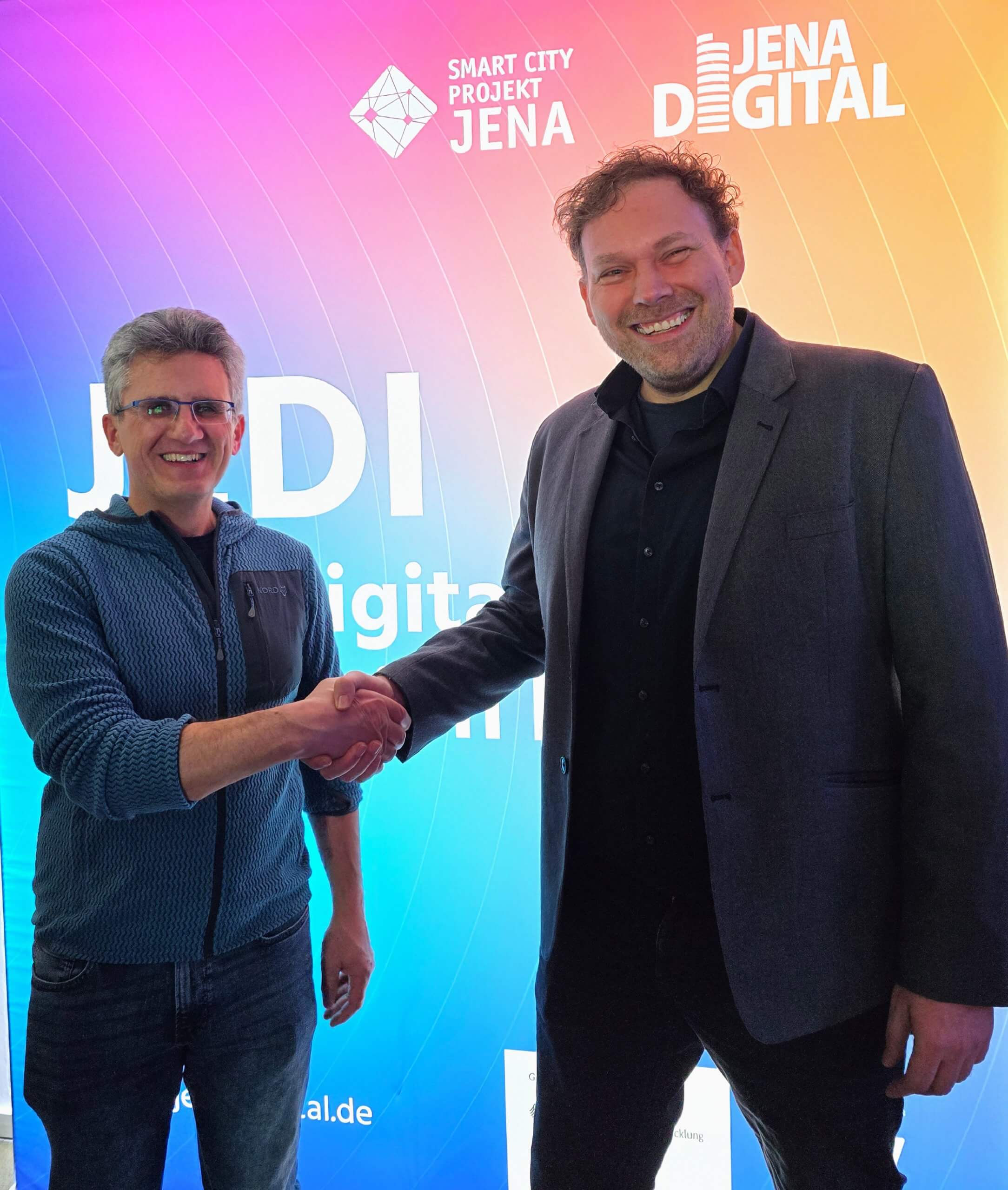 ORISA Partnerschaft rooom AG Matthias Schwuchow (Geschäftsführer ORISA Software GmbH, links) schüttelt die Hand von Hans Elstner (Geschäftsführer rooom AG, rechts) auf dem Member Monday von JenaDigital